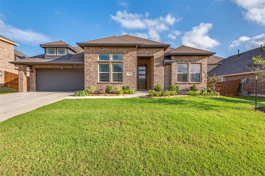 Prairie-style home featuring a front lawn and a garage