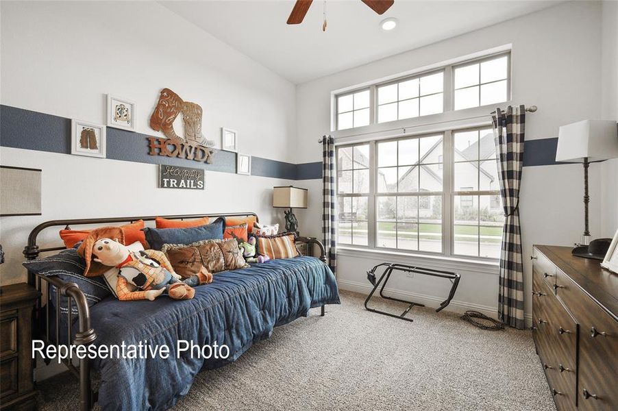 Carpeted bedroom featuring multiple windows and ceiling fan