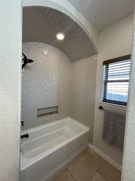 Bathroom with independent shower and bath and tile patterned floors