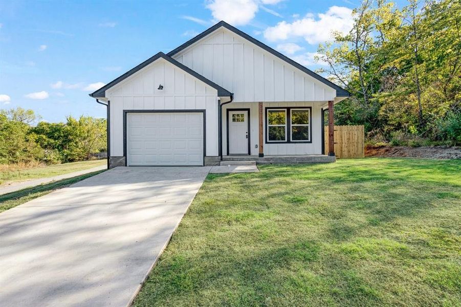 Modern farmhouse with a front lawn and a garage