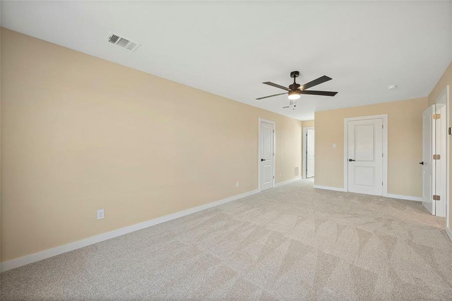 Carpeted empty room with ceiling fan