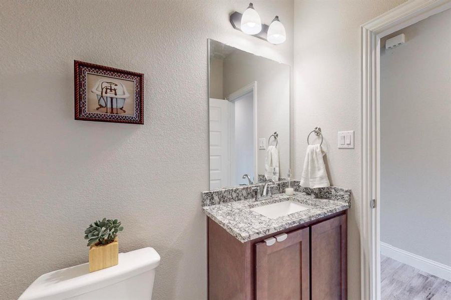 Bathroom featuring hardwood / wood-style floors, toilet, and vanity