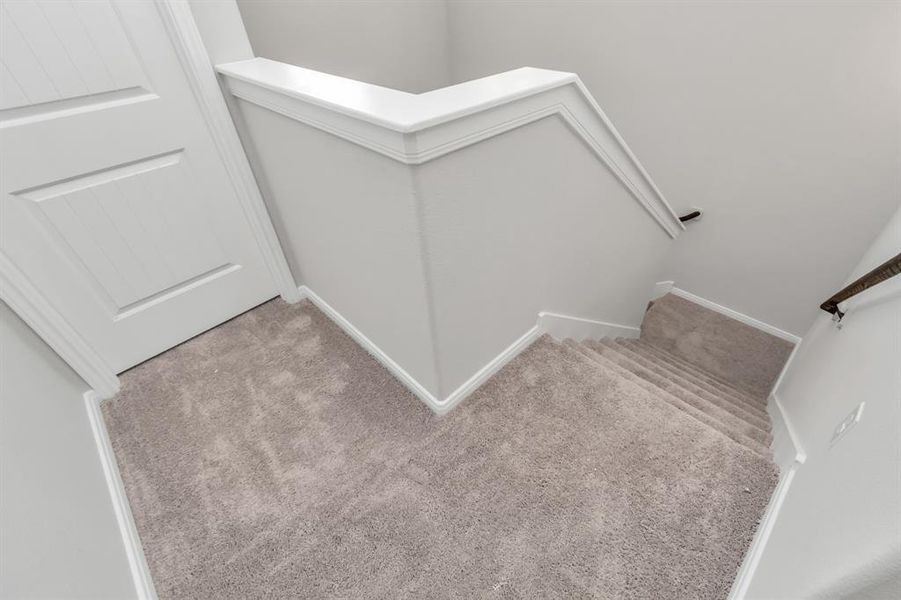 The carpeted staircase in this home adds both comfort and style, leading you from the main living areas to the private upper level. The neutral tones and soft carpeting create a warm, inviting atmosphere, making it easy to envision this space as part of your daily routine. Whether you're heading up to the bedrooms or down to the kitchen, this staircase is both practical and aesthetically pleasing. **This image is from another Saratoga Home with similar floor plan and finishes, not the June floorplan.**