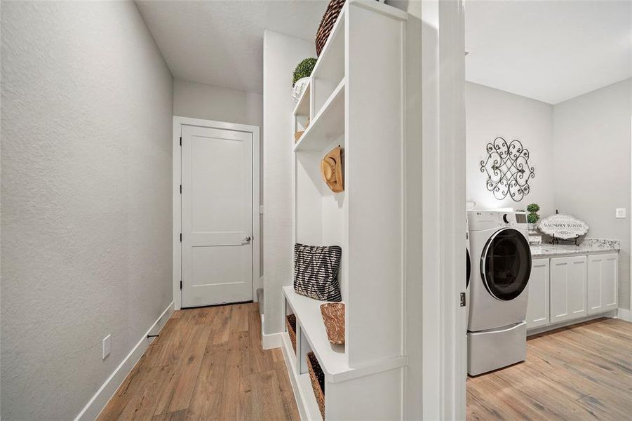 Keep everyone organized with this convenient mud room with a built-in hall tree for coats, backpacks, shoes and more. Notice the easy access to the laundry room and primary suite through that.