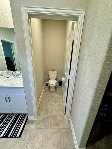 Bathroom with vanity, toilet, and tile patterned floors