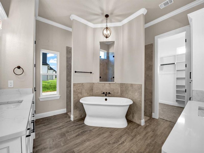 Bathroom featuring vanity, crown molding, tile walls, and a washtub