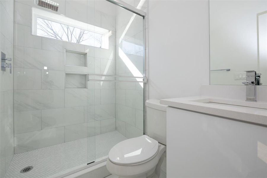 Bathroom featuring walk in shower, toilet, and vanity