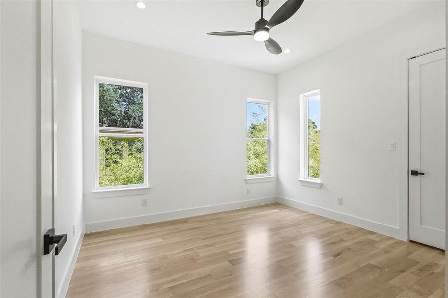 Empty room with light hardwood / wood-style floors and ceiling fan