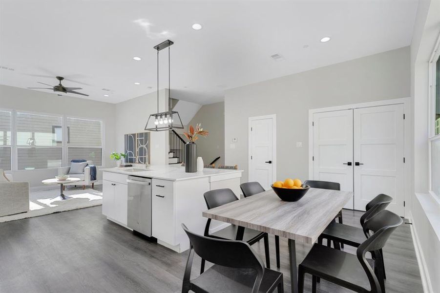 Dining room with ceiling fan with notable chandelier, hardwood / wood-style floors, and sink