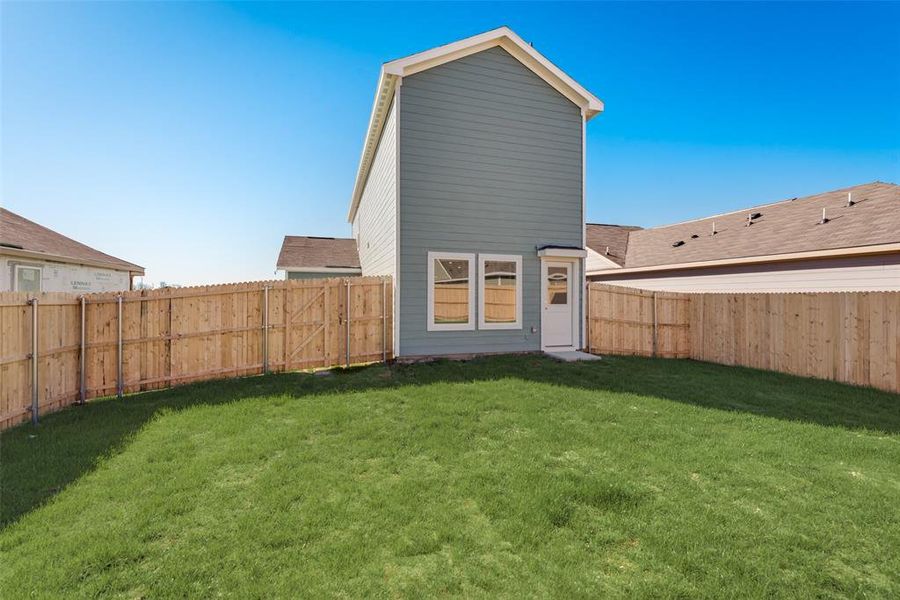 Back of house featuring a yard