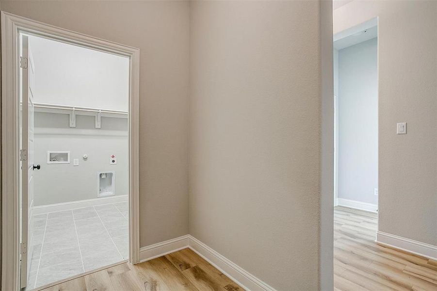 Clothes washing area featuring hookup for a washing machine, gas dryer hookup, and light hardwood / wood-style flooring