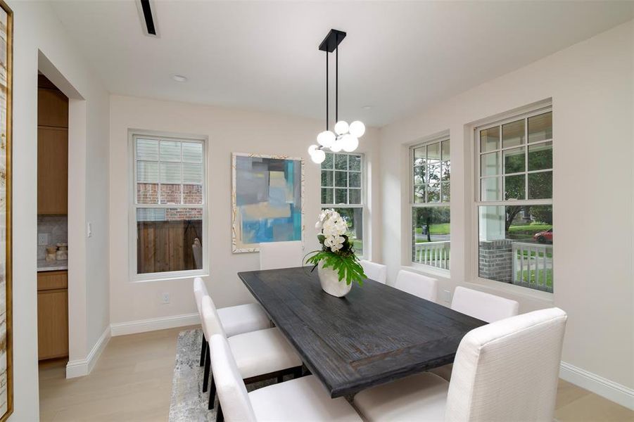 Dining space with a wealth of natural light, light hardwood / wood-style flooring, and a notable chandelier