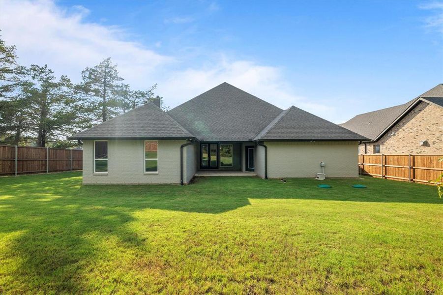 Rear view of property with a yard