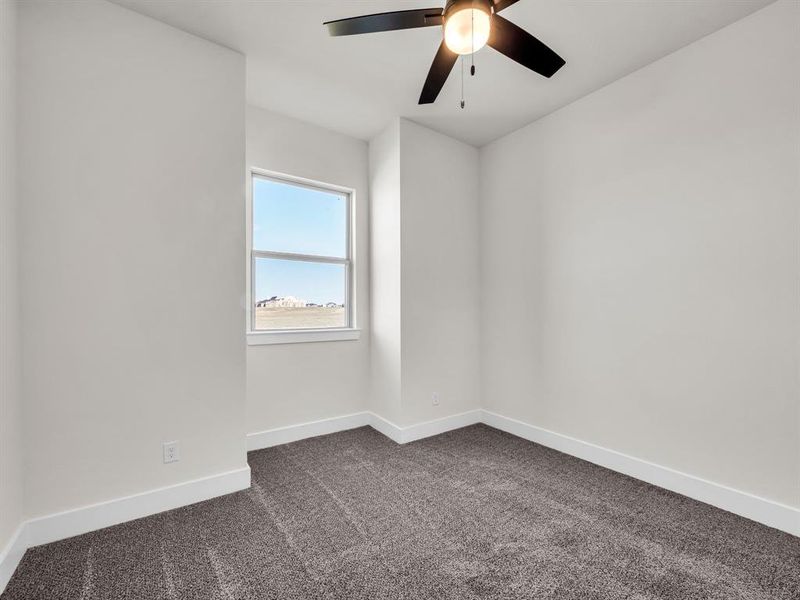 Carpeted empty room with ceiling fan