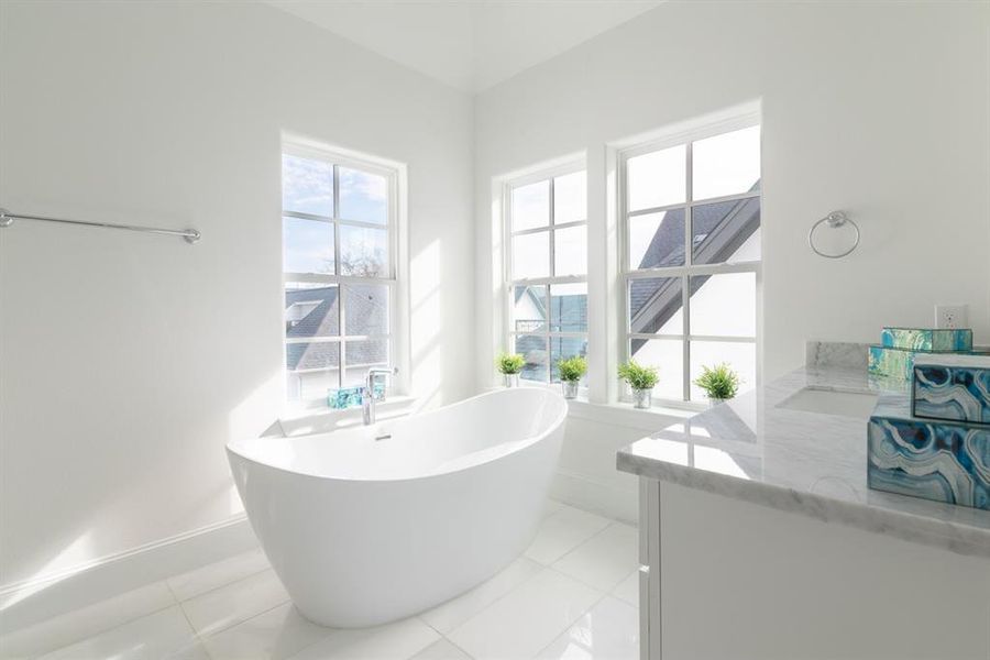 Primary bath with a floating tub, separate vanities, and good natural light. (similar home and features)