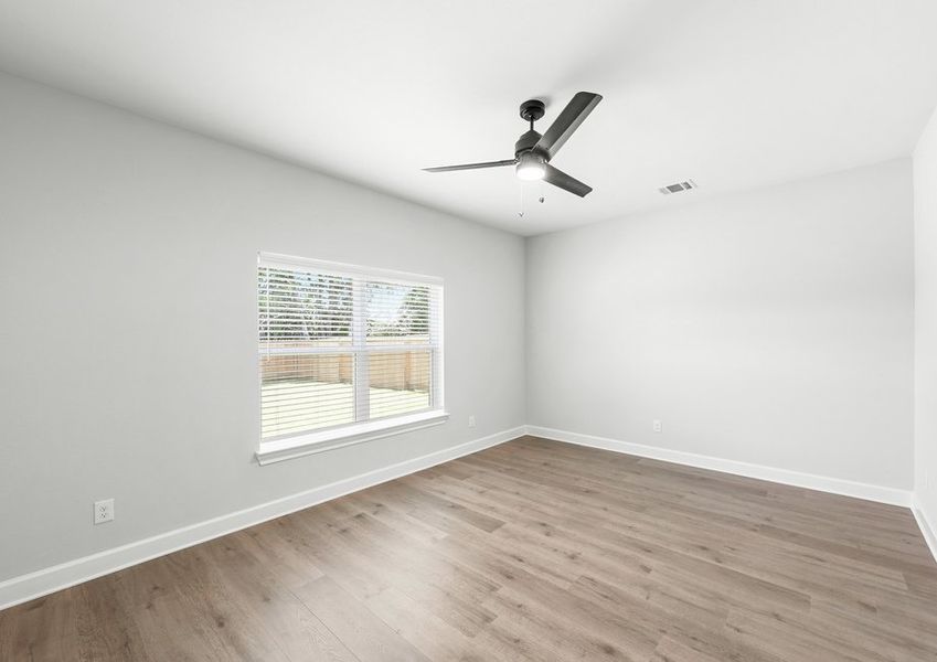 The master bedroom of the Driftwood has a large window that lets in natural light and backyard views.