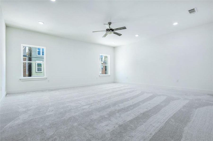 Empty room featuring carpet floors and ceiling fan