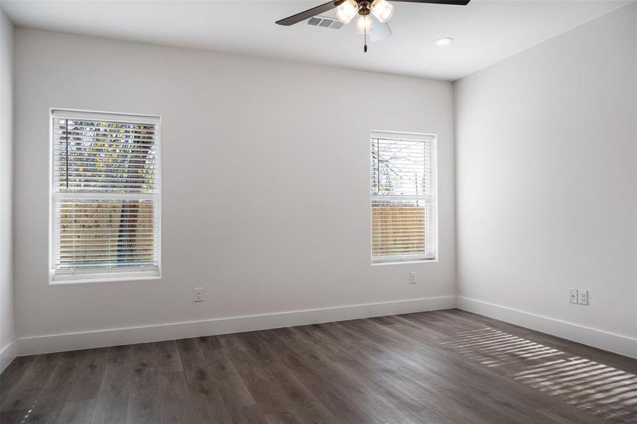 Unfurnished room featuring ceiling fan and dark hardwood / wood-style flooring