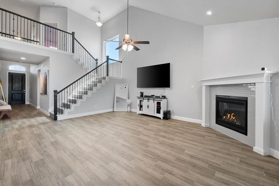 Unfurnished living room featuring ceiling fan, hardwood / wood-style floors, and high vaulted ceiling