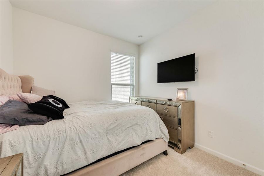 Bedroom featuring light carpet