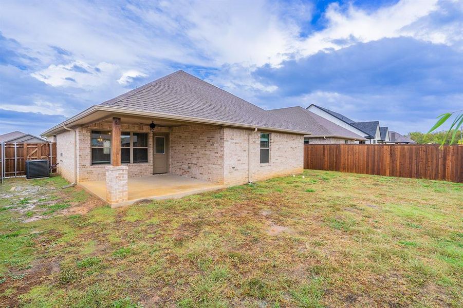 Back of house with ceiling fan, a yard, cooling unit, and a patio area