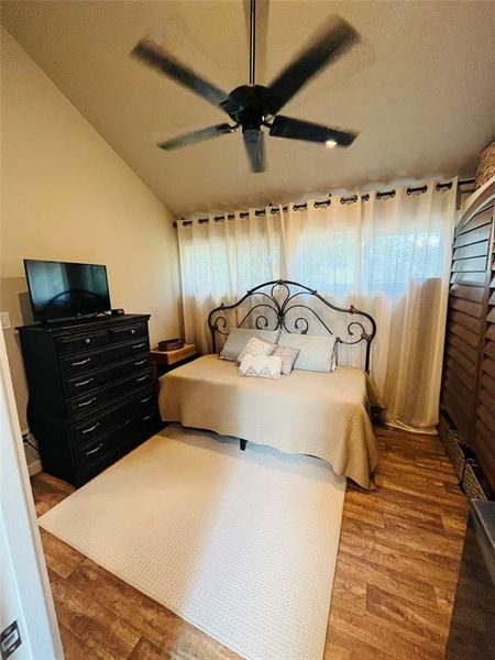 Bedroom featuring lofted ceiling, ceiling fan, and hardwood / wood-style floors