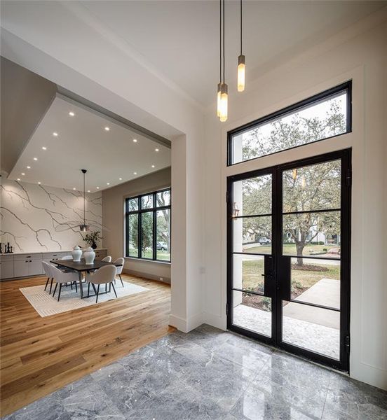 Entry foyer with elegant lighting fixture transitioning into the dining room