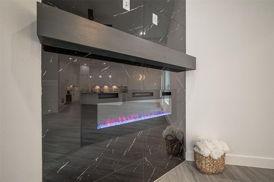 Electric fireplace, runs the length of the wall and has a black finish.