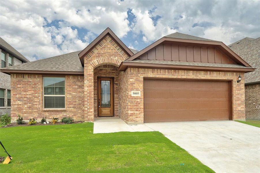 View of front of property with a garage and a front yard