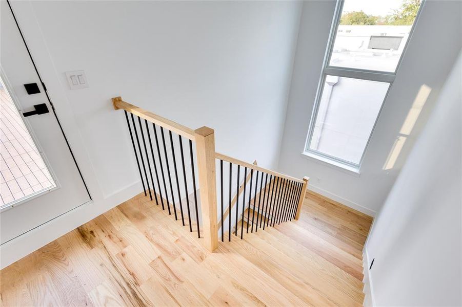 Staircase with wood-type flooring and a wealth of natural light