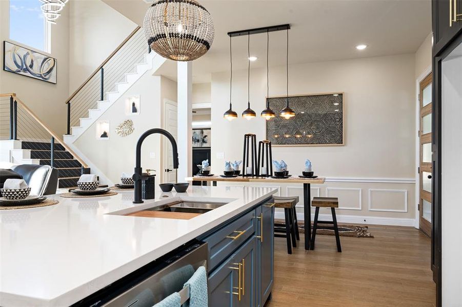 Kitchen featuring dishwasher, a notable chandelier, sink, hanging light fixtures, and light hardwood / wood-style flooring