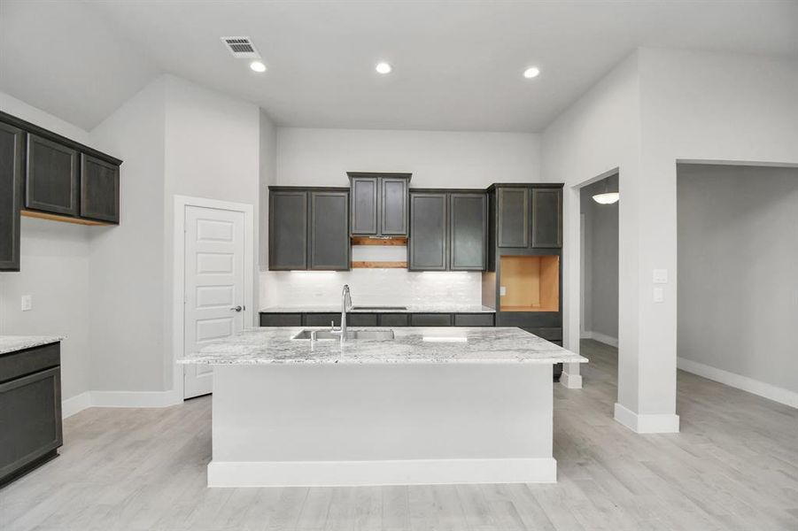 Discover another perspective of this stunning kitchen, generously appointed with an abundance of counter space.