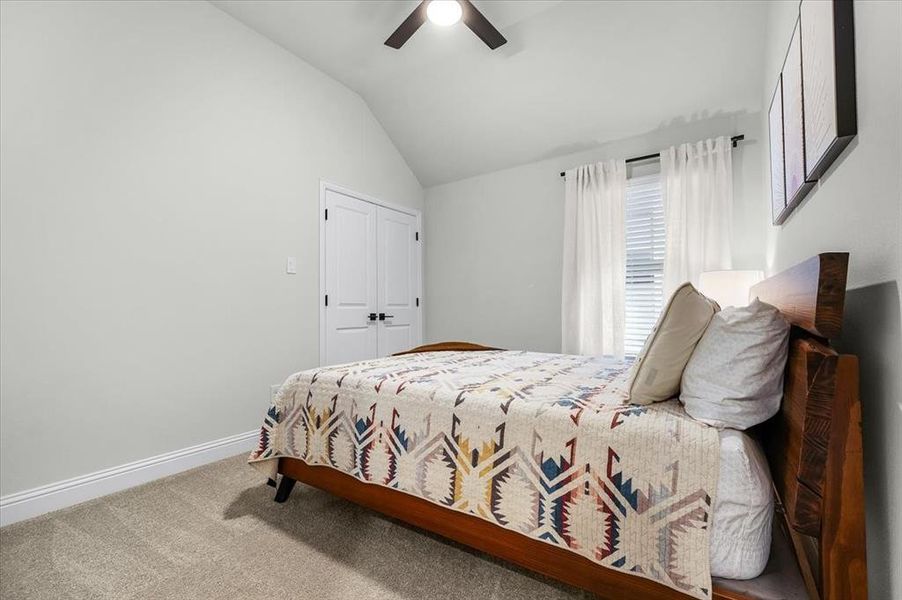 Bedroom featuring carpet floors, a closet, ceiling fan, and lofted ceiling