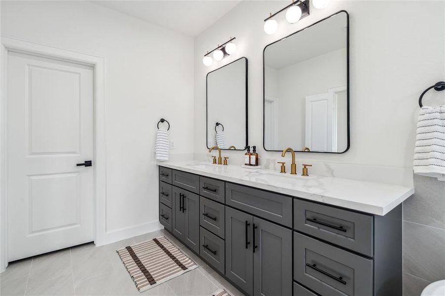 Luxurious bathroom, featuring expansive quartz countertops, his-and-hers sinks, ample drawer storage, and generous cabinet space. Designed for ultimate comfort and organization.