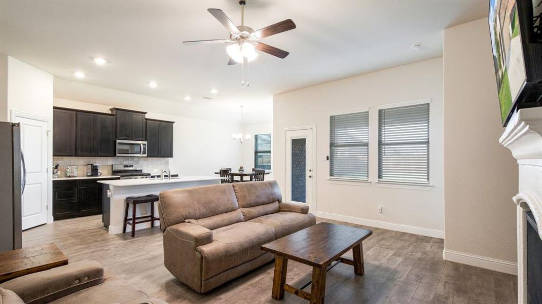 Living room featuring sink, ceiling fan with notable chandelier, and hardwood / wood-style floors