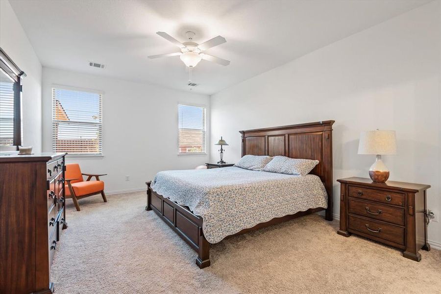 Bedroom with ceiling fan and light colored carpet