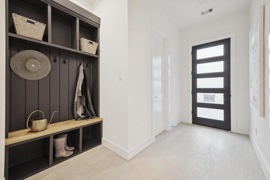 Upon entry into this beautiful model home, you will find a quaint mudroom space/accent wall, gorgeous white oak hardwood floors, and bright LED lighting complete with 1st floor living!