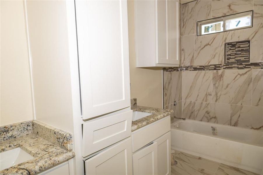 Bathroom with tiled shower / bath and vanity