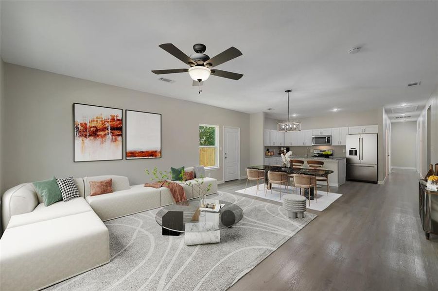 Living room featuring ceiling fan with notable chandelier and hardwood / wood-style flooring