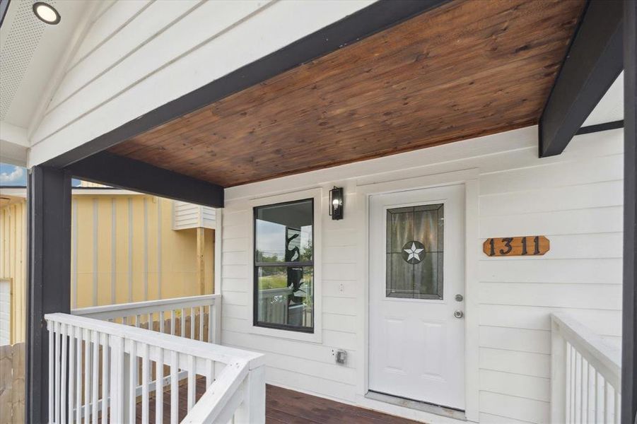 All that's missing from this picturesque scene is a porch swing and a glass of wine. With a wood-slat ceiling, Lone Star door, chic lighting and fresh paint, this covered porch warmly welcomes you to a fabulous home.