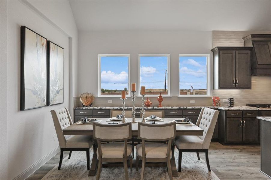 Dining room featuring vaulted ceiling and light hardwood / wood-style floors