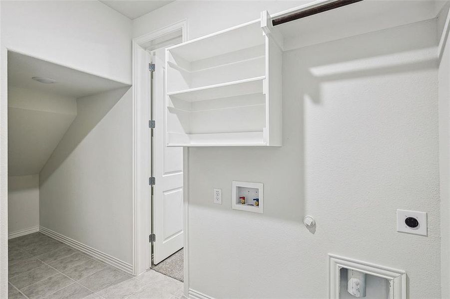 Clothes washing area with hookup for a washing machine, gas dryer hookup, light tile patterned floors, and hookup for an electric dryer