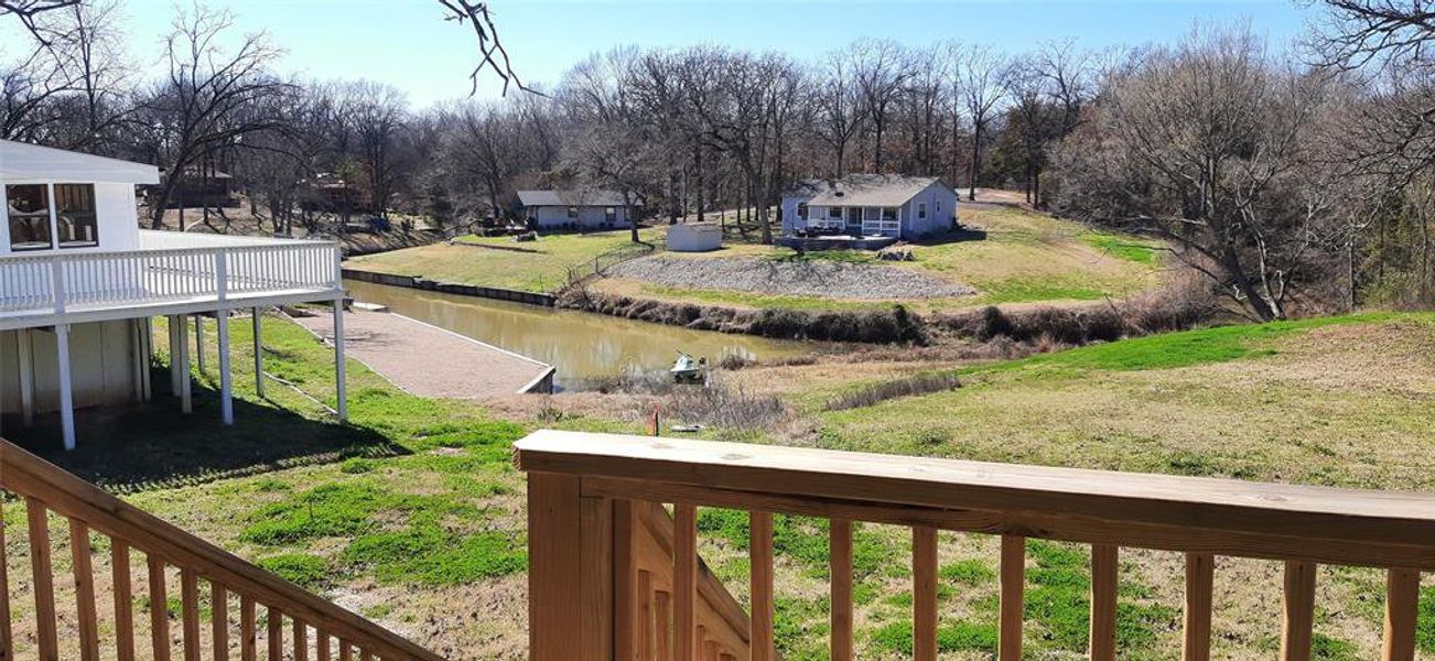 View of yard with a deck with water view