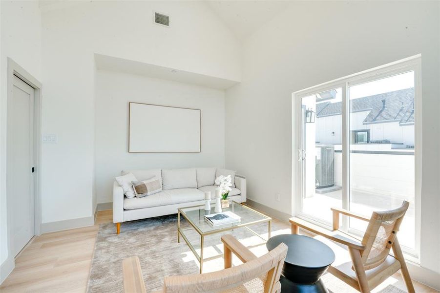 Living room featuring light hardwood / wood-style floors and high vaulted ceiling