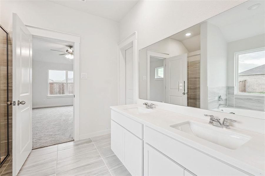 Bathroom featuring dual vanity, tile patterned floors, a bathtub, and ceiling fan