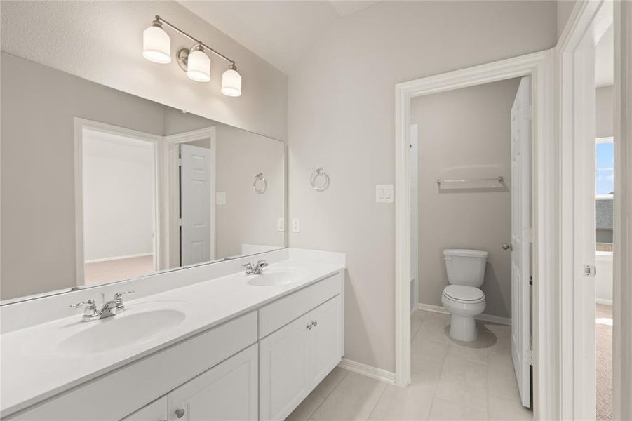 The en-suite bathroom offers a spa-like atmosphere with its elegant design, high end finishes, and tasteful lighting, creating a retreat within your own home.