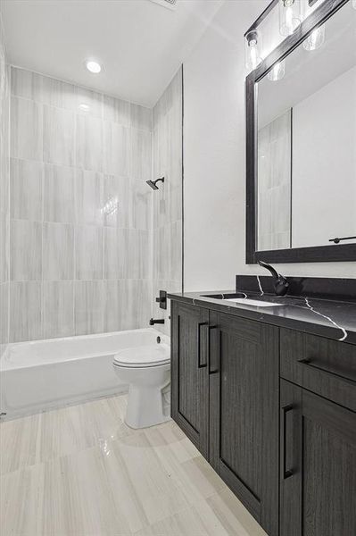 Full bathroom featuring tiled shower / bath, toilet, and vanity