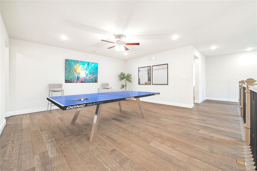 At the top of the stairs is this open concept game room area, ideal for entertaining. *This photo has been virtually staged*