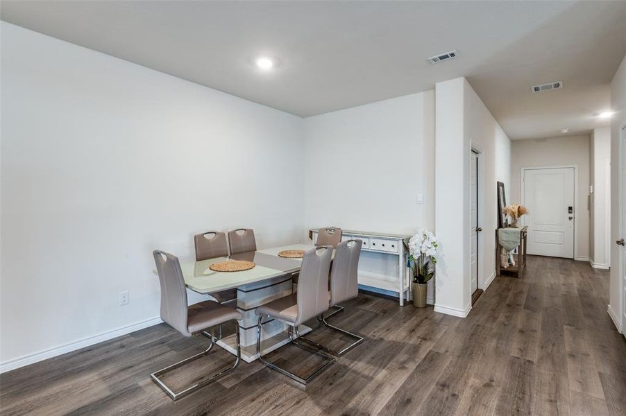 Dining space with dark hardwood / wood-style floors