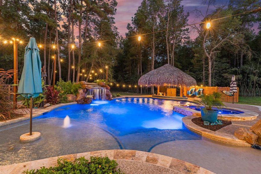 This view shows the beach entry on the right, the sun shelf on the left, large grotto with soothing waterfall, hot tub and exotic tiki!